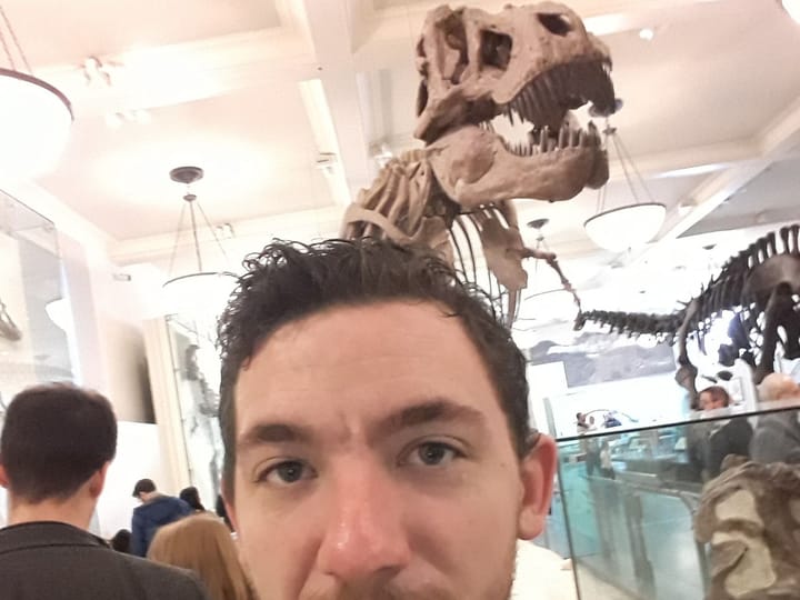 A selfie in front of a mounted T. rex skeleton at the American Museum of Natural History