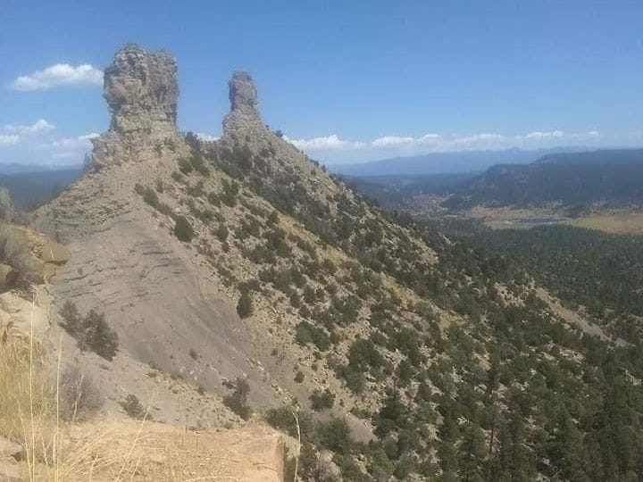 The two Chimney Rock spires on a ridge above a forested valley