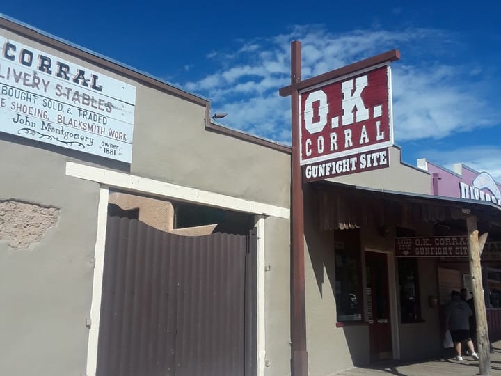 The O.K. Corral Gunfight Site sign beside the old corral stables